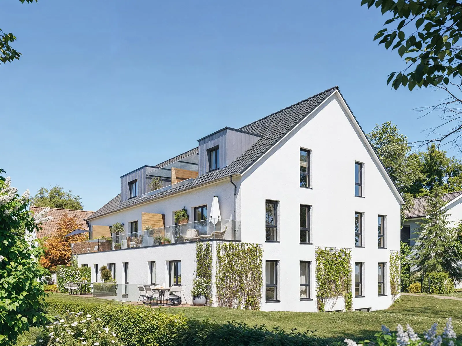 Fotorealistische Architekturvisualisierung eines weißen Mehrfamilienhauses mit Balkonen im Grünen | build-av.de