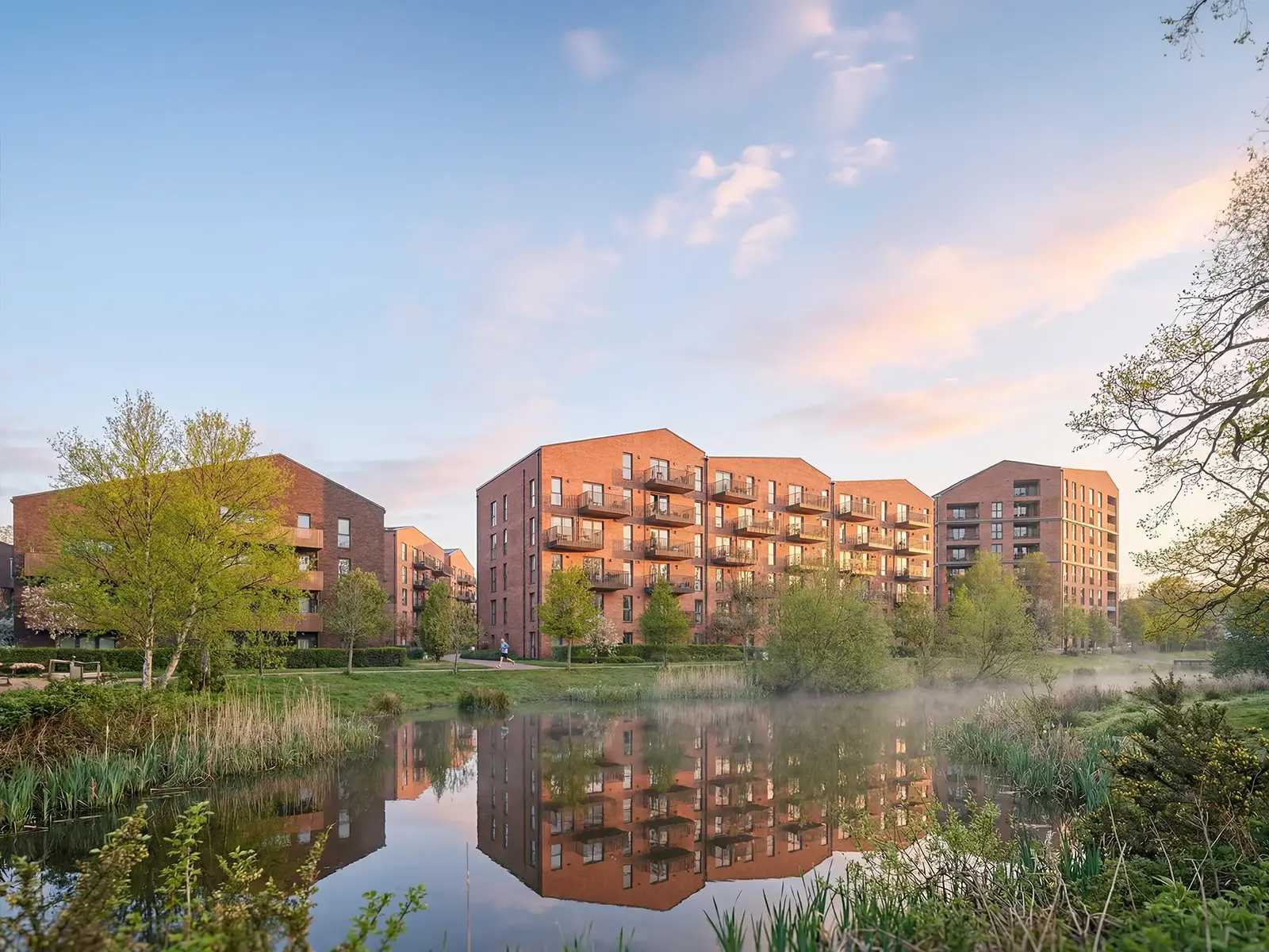 Fotorealistische Architekturvisualisierung eines Backstein-Wohnquartiers am Wasser in der Abendstimmung – build-av.de