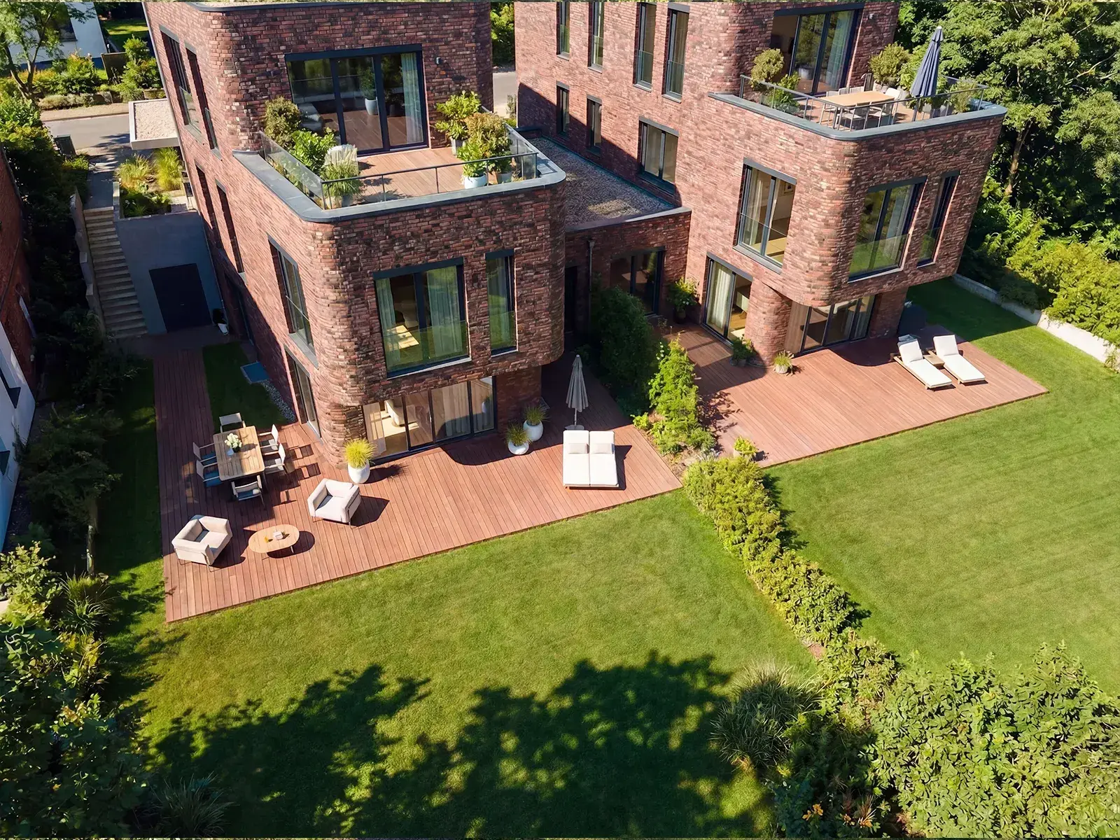Architekturvisualisierung von Klinker-Reihenhäusern mit Dachterrassen und Gärten aus der Vogelperspektive in Lübeck | build-av.de